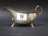 Silver sauce boat with flying scroll handle upon triple legs, Birmingham 1937, 3.5oz.