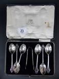 Cased set of 6 silver teaspoons with sugar tongs, pierced scroll handles.