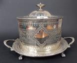 Silver plated oval lidded biscuit barrel decorated with engraved bands, a twin handled stand