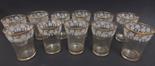 Set of 11 glass wine beakers with frosted and enamel bands of fruiting vine, gilt rims, height 4”.