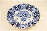 Dutch delft charger, 18th Century, centred with a formalised fern arrangement within a formal