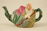 Chinese famille rose ornamental teapot, modelled as a wise traveller seated against a giant peach,