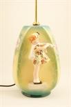 Goldscheider figural table lamp, the base of ovoid form supporting a figure of a girl putting on