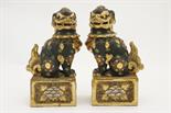 Pair of Japanese shi-shi dogs, each modelled seated on a plinth and decorated with gilt against a