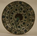 Persian Iznik dish, decorated with stylised flowers in blue and terracotta, 26cm diameter