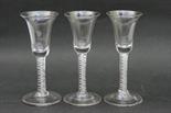 Three George III opaque airtwist wine glasses, each with trumpet bowl over a graduated opaque