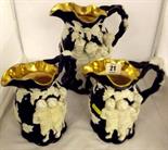 VICTORIAN STONEWARE; three gilded rimmed graduated jugs decorated with relief Bacchus designs (