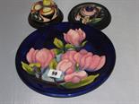 MOORCROFT; two wooden mounted Moorcroft jar lids; also Moorcroft style blue ground Magnolia dish
