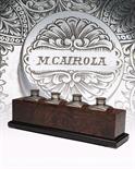 A SET OF FOUR MUFFOLINI-ENGRAVED OIL BOTTLES set in a burr walnut plinth engraving by master