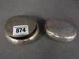 Two silver tobacco boxes one round and one oval both with chased decoration, inscription to cover