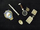 A silver petrol lighter, a medal, a magnifying glass, pencil, gilt and enamel badge and a fob