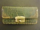 A green Crocodile purse with silver corners and clasp 
Condition report:  General wear, in need of a