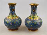 A pair of Chinese cloisonne globular vases with flared necks decorated with flowers and foliage on a