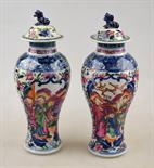 A pair of Chinese famille rose small baluster vases and covers, each decorated with panels of