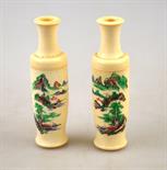 A pair of Chinese ivory miniature cylindrical vases incised and painted with a mountainous watery