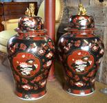 A pair of modern Chinese famille noir large baluster vases and covers decorated with panels of