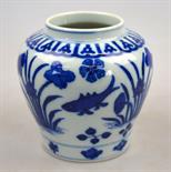 A Chinese blue and white small baluster jar decorated with four carp swimming between flowering