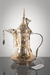 OMANI WHITE METAL AND BRASS COFFEE POT with stylised floral motifs and hanging appendages, 28cm high