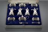 SILVER TEN-PIECE CRUET SET of serpentine rectangular form, with pad feet, Chester 1919, in