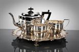 GEORGE V SILVER THREE PIECE TEA SERVICE comprising teapot, sugar, and cream, of irregular oval form,