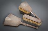 ART DECO SILVER THREE PIECE VANITY SET comprising a brush, hand held mirror, and clothes brush, each