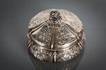 CONTINENTAL SILVER CIRCULAR BOX AND COVER of bulbous form, with a scrolling finial and decorated