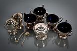 SILVER SEVEN-PIECE CRUET SET of circular form with shaped handles, maker GM, Sheffield 1908,