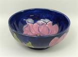 A Moorcroft pottery bowl decorated in the 'Magnolia' pattern against a cobalt blue ground,