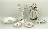 A German porcelain figure of a lady, early 20th century, modelled standing in a net dress bedecked
