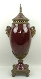 A porcelain and brass urn and integral cover, 20th century, red ground with twin satyr handles, leaf