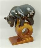 A USSR pottery figure of a bear modelled standing on a wheel and wedge shaped base, printed mark,