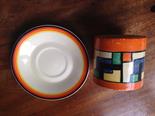 Clarice Cliff Bizarre pattern saucer and jar mising lid, rubbed.