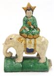 Chinese glazed ceramic roof tile, of a female deity holding a fan and seated above an elephant,