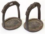 Pair of Chinese iron stirrups, the handle decorated with two dragon heads, above the oval section