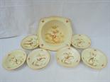 A Crown Ducal blush ivory dessert set of six bowls and a serving dish bearing floral decoration with