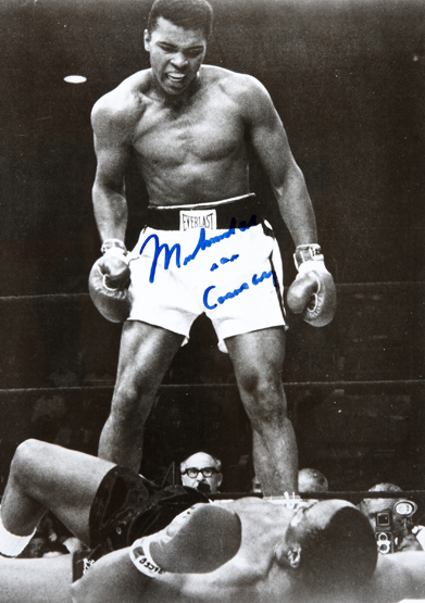 A Muhammad Ali signed b&w photograph of him standing over Sonny Liston, 10 by 8in., signed in blue