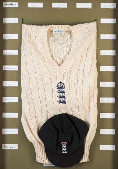 A framed display featuring an England cricket cap and sweater and the autographs of 23 England