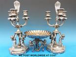 A pair of "Pairpoint" silver plated and glass candelabra, supported by cherubs together with a
