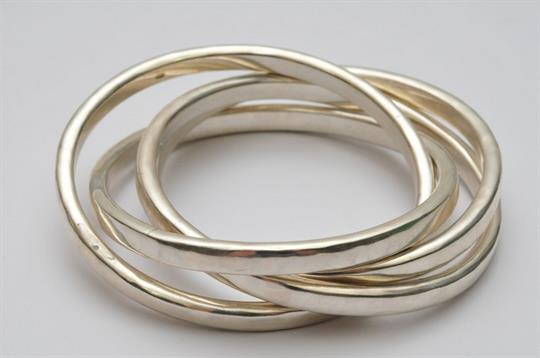 a heavy hammered silver bangle formed from three interlocking rings three interlocking rings
