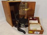 A cased microscope with some specimen slides and unused slides (qty)