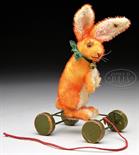 BRIGHT ORANGE MOHAIR STEIFF RABBIT WITH BUTTON ON WOODEN ECCENTRIC WHEELS. Rabbit is begging, head