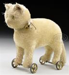 EARLY WHITE STEIFF MOHAIR CAT WITH BUTTON ON WHEELS. This circa 1909 cat is standing, unjointed and