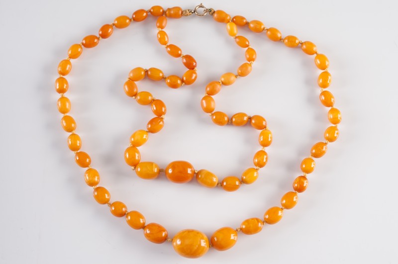 A graduated amber bead double string necklace:, the beads graduated from 9mm long - 24mm long, 46gms