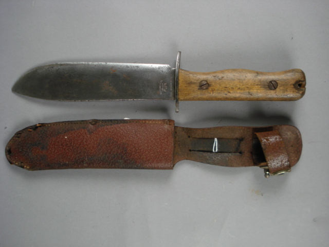 A WWII combat knife by Wilkinson Sword Co, stamped `1B/4594` to ricasso, two piece wooded grip,