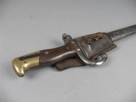 A WWI Gras pattern bayonet in scabbard, the 52cm blade signed to tang, two piece wooden and brass