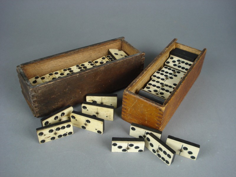 Two sets of bone and ebony dominoes.