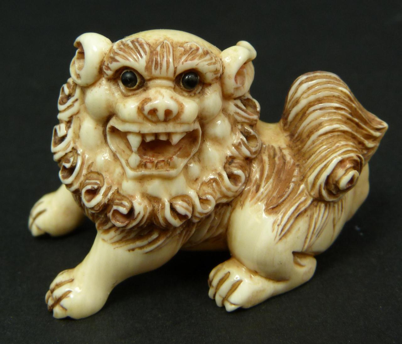 CARVED IVORY NETSUKE OF FOO DOG, SIGNEDHand carved Japanese ivory