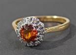 18 carat gold ring, set with central brilliant cut orange citrine, surrounded by twelve diamonds,