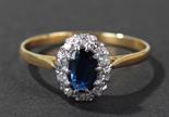 18 carat gold diamond and blue sapphire set ring, centered with single oval cut blue sapphire,