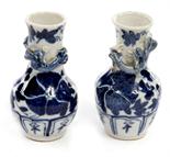 A PAIR OF SMALL JAPANESE BLUE AND WHITE PORCELAIN VASES, 
19th century, each overlaid with a dragon,